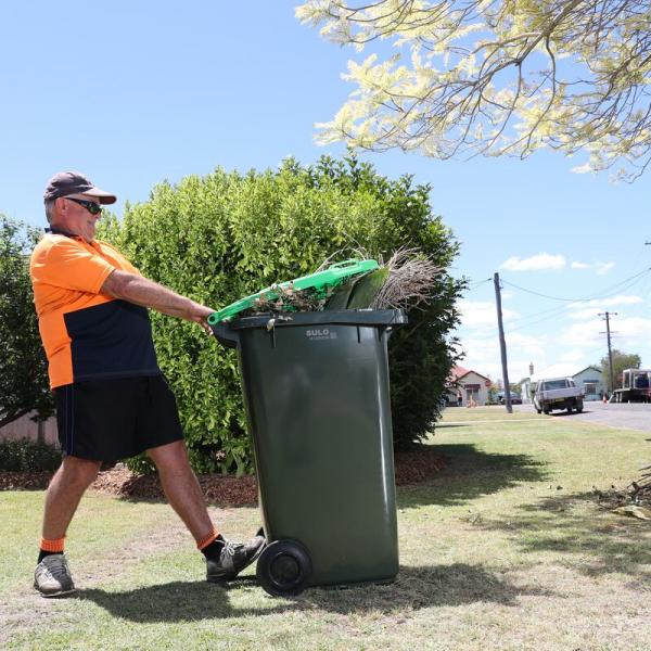 Man putting bin on kerbside in Maitland