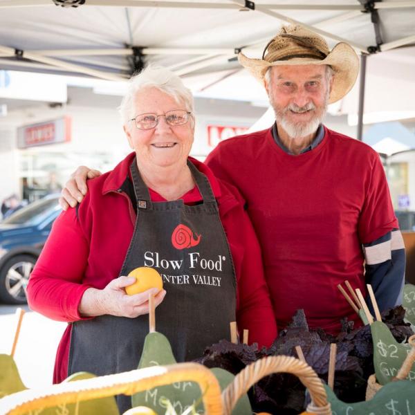 Couple selling produce at market stall