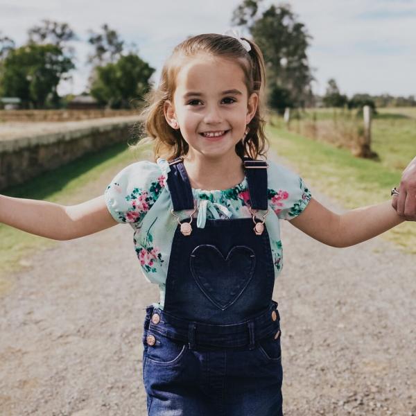 Young girl holding hands on a path