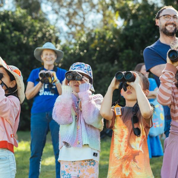 Group of children looking through binoculars
