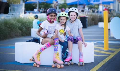 Three girls sitting with roller skates on