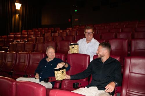 Craig Hamilton sitting with Mayor Philip Penfold and Jye Currie in the movie cinema