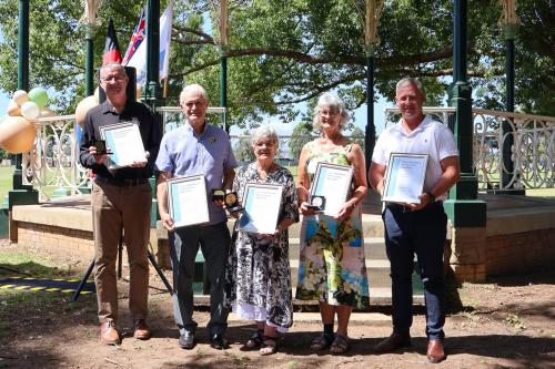 Group of five people holding awards 