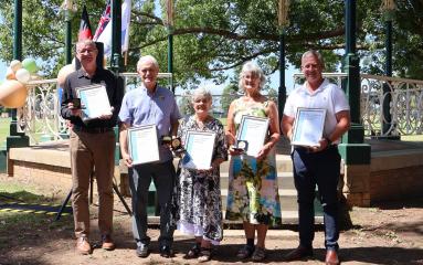 Group of five people holding awards 