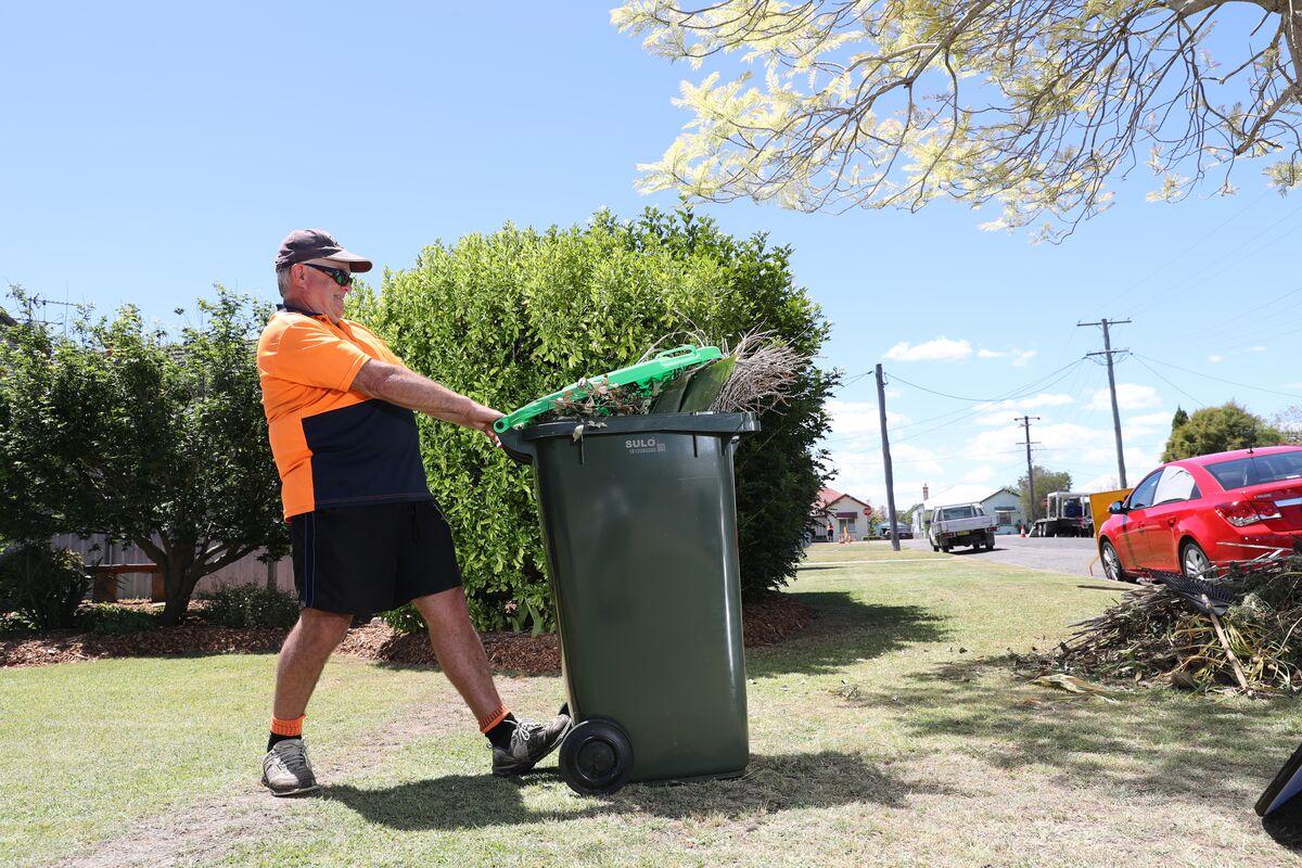 Man putting bin on kerbside in Maitland