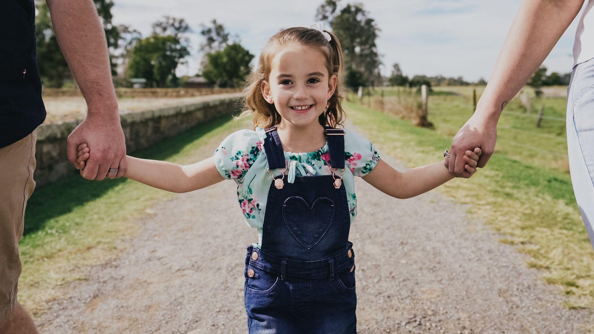 Young girl holding hands on a path
